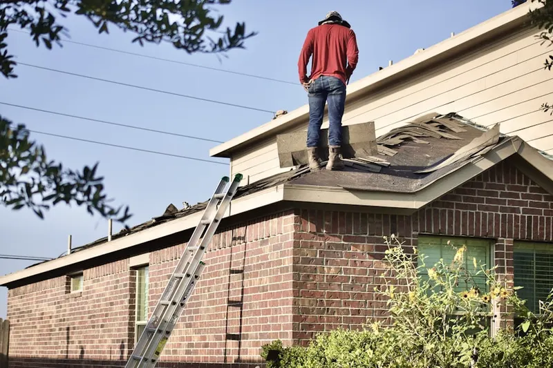 Professional roofer working on a residential roof in Enchanted Lake Estates